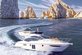 Yate con flybridge navegando frente a El Arco