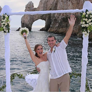 Pareja de recién casados frente a El Arco de Cabo San Lucas