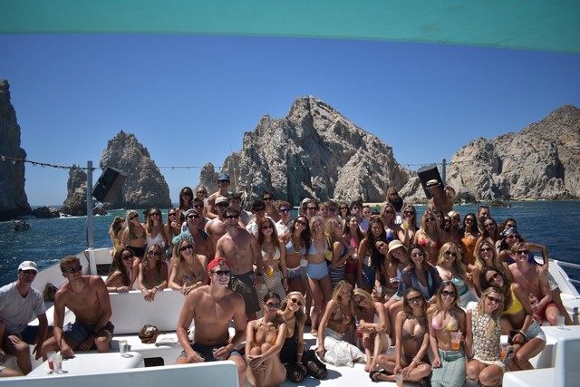 Grupo grande a bordo de un yate frente a El Arco de Cabo San Lucas